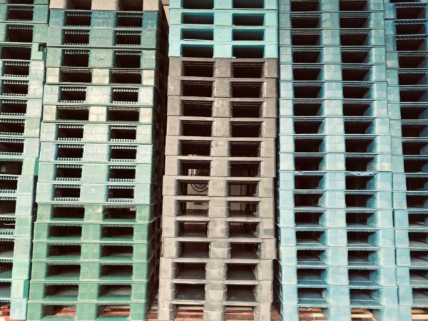 Plastic pallets are stacked and waiting to be used in the manufacturing industry